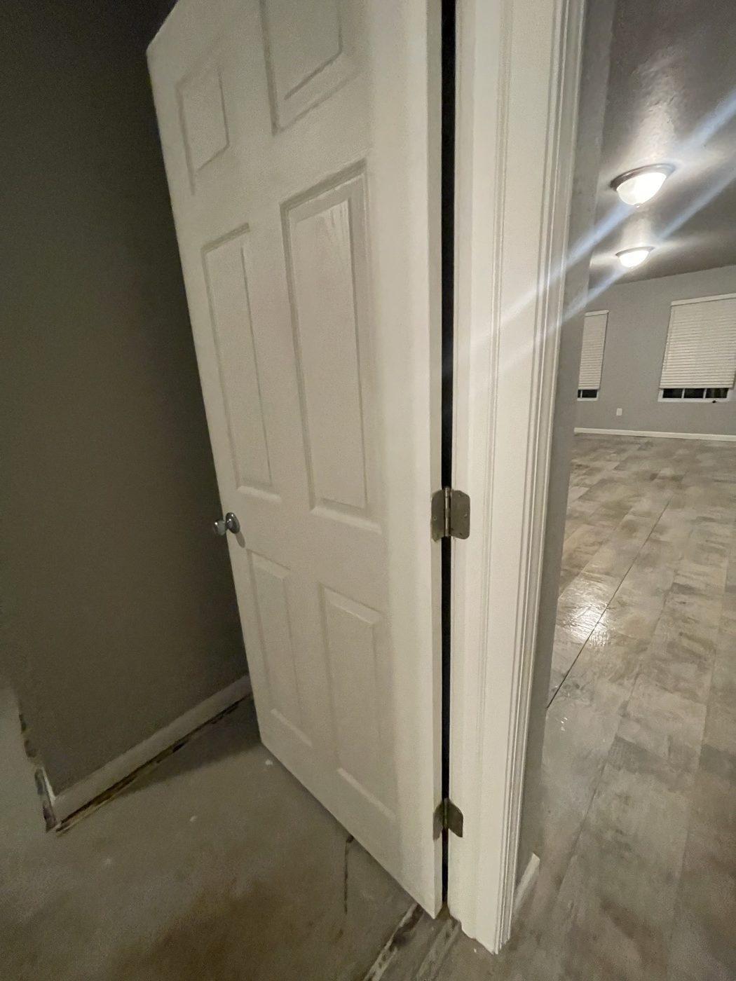 New interior door hung on fresh hinges, opening into a finished room
