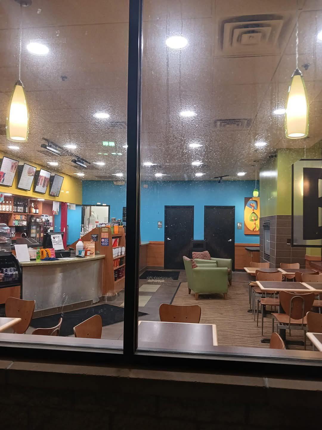 Café seating area with a suspended tile ceiling and recessed lighting after refurbishment
